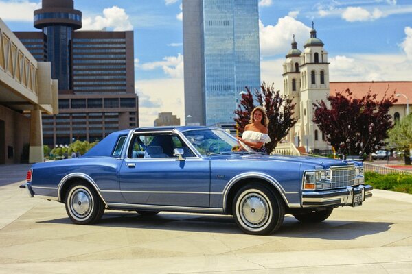 Ein schönes Auto aus dem Jahr 1979 vor dem Hintergrund der Kirche und ein schönes Mädchen 