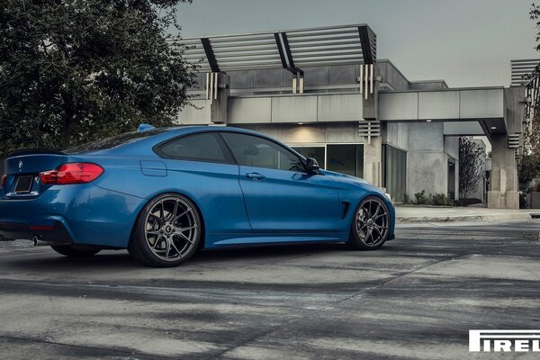 Coche azul BMW . F32. Vista trasera lateral