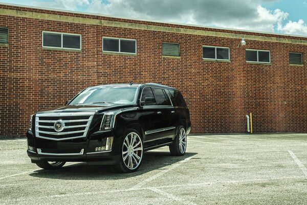 Cadillac noire sur fond de brique