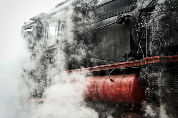 Locomotive à vapeur avec réservoir rouge dans la fumée