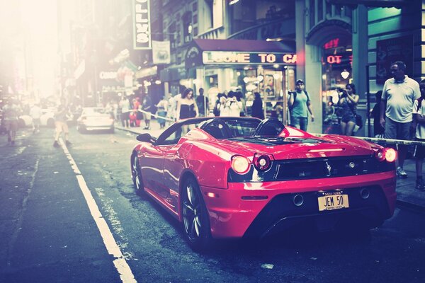 El coche de Ferrari en rojo en la calle de la ciudad