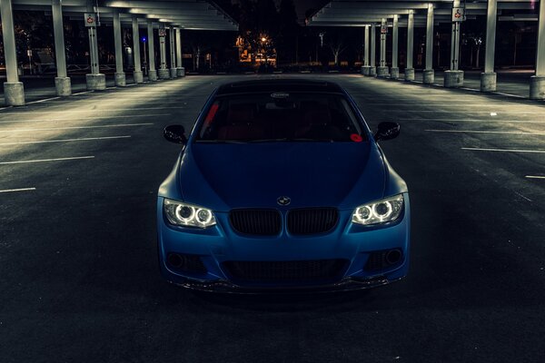 A blue BMW is parked in the parking lot