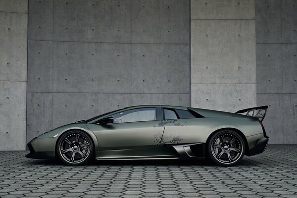 La Lamborghini grigia e super veloce si fonde con lo sfondo grigio 