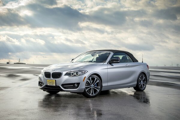 BMW convertible silver car on a wet road