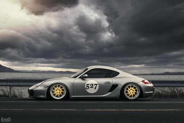 Porsche-metallic on the background of the highway and thunderclouds 