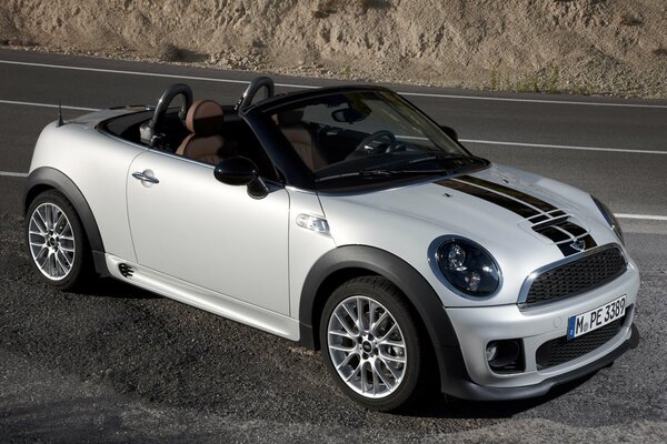 Mini Cooper blanc sans dessus sur une route grise