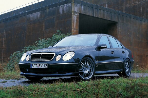 Mercedes-Benz auf dem Hintergrund von Garagen und Gras