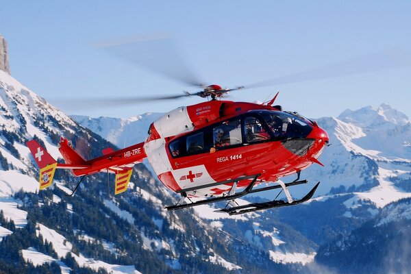 Rescue helicopter hovered over the mountains in winter