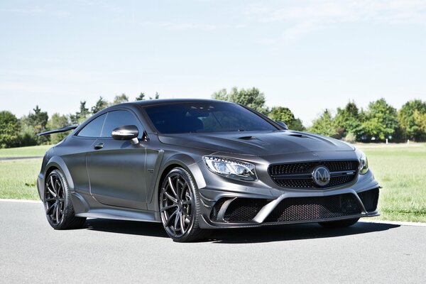 Un coche gris recorre la carretera en verano