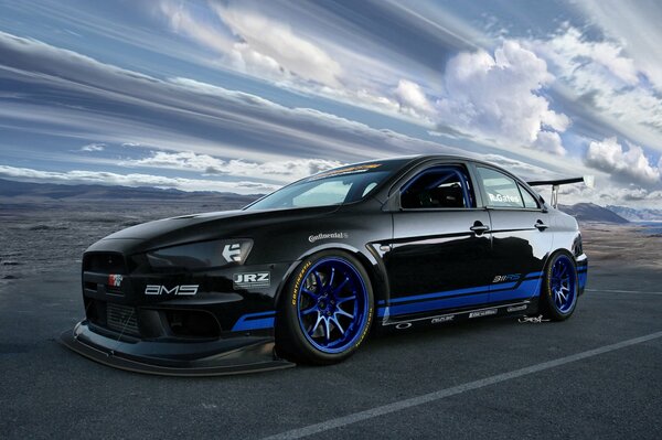 Mitsubishi evolution x stands against the background of the rushing sky