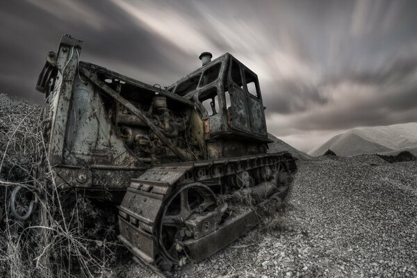 The old tractor stands alone. night, gloomy