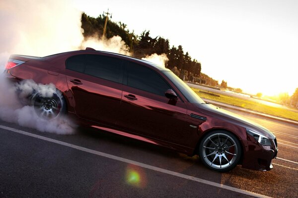 Drift BMW mit Rauch auf dem Hintergrund der Morgendämmerung