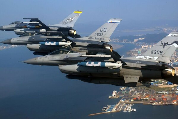 Varios aviones militares sobre el mar y la ciudad