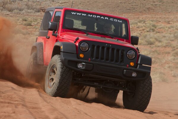 Red jeep crosses the desert