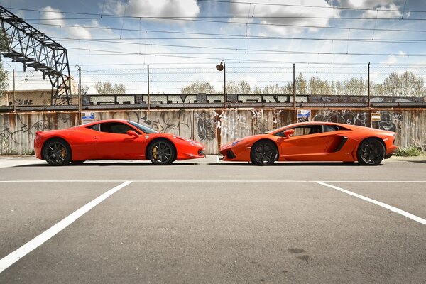 Orange Lamborghini und Ferrari stehen von Angesicht zu Angesicht