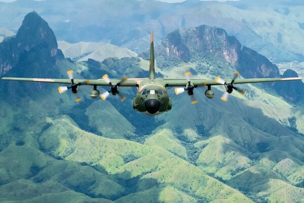 Avion militaire Hercules, c-130H au-dessus des montagnes