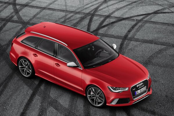 Audi rojo conduce por el campo de fútbol