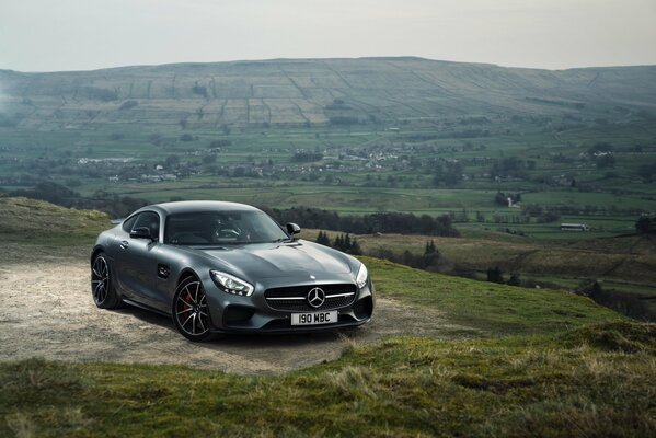 Voiture noire mercedes amg au milieu des pistes de montagne