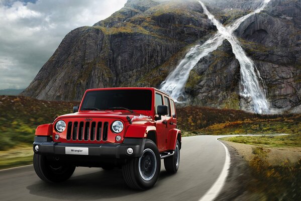 Wrangler X car on a mountain road on the background of a waterfall