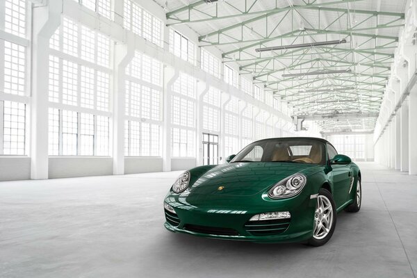 Porsche verde in un parcheggio bianco come la neve