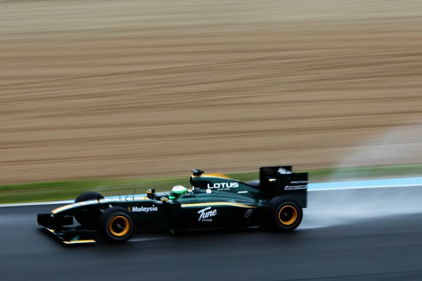 A black racing car rushes along the track