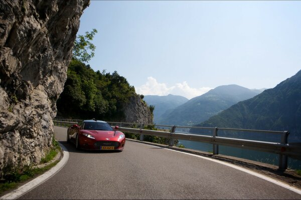 Voiture de sport rouge parmi les montagnes et la serpentine