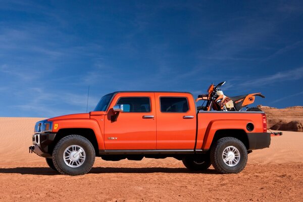 The car is standing on a sandy surface