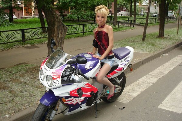 Frau in einem Minikleid mit einem Motorrad unterwegs
