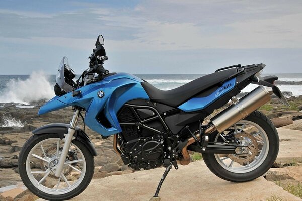 Bicicleta azul en el fondo de una playa rocosa