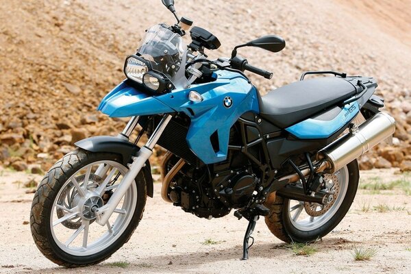 Blue BMW bike on the background of rocky soil