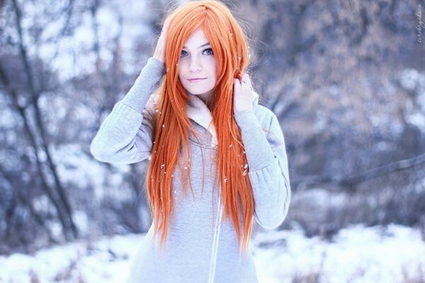 Hermosa chica con el pelo rojo en invierno