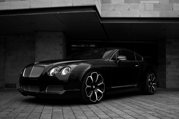 Bentley en noir et blanc parmi les murs de briques