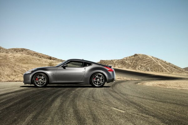 Grauer nissan 370z auf der Straße in der Wüste