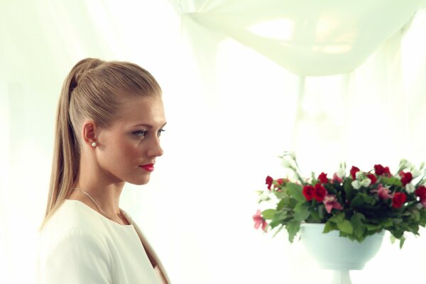 Asmus Kristina looking at a bouquet of flowers in a vase