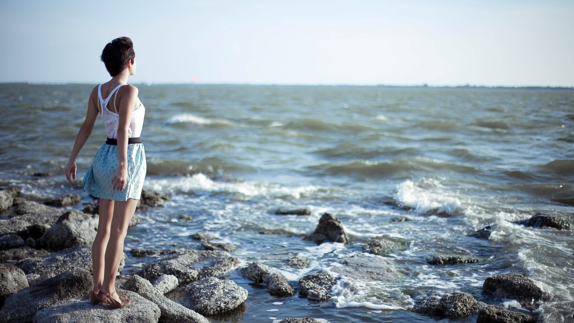 mujer chica morena piedra gris mar agua océano