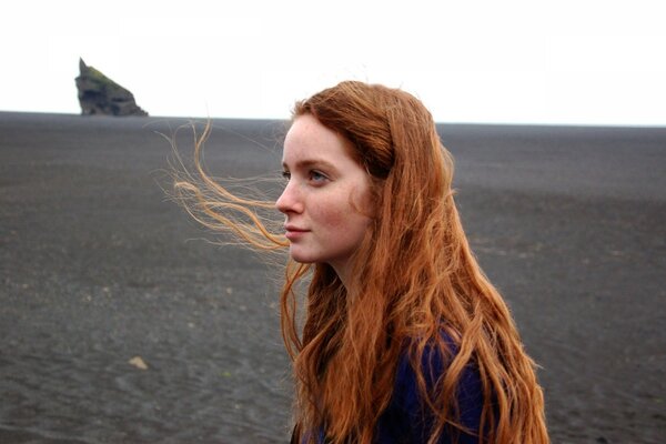 Rousse fille au milieu d un champ gris