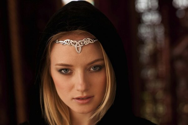 A woman in a velvet cape on her forehead with a decoration