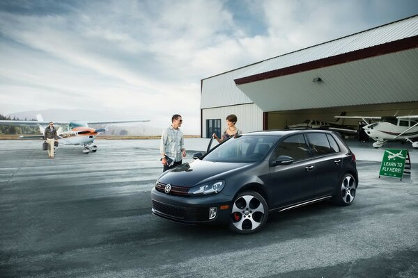 Volkswagen en el estacionamiento cerca del hangar de aviones