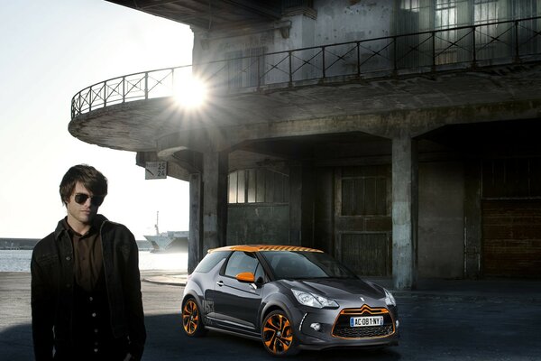 Young guy next to a cool car