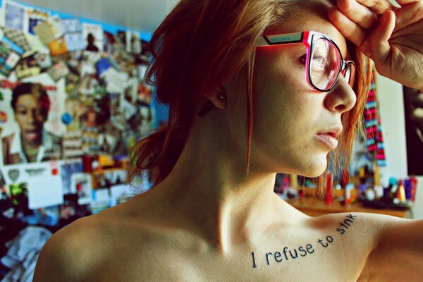 Red-haired girl with a tattoo on her collarbone