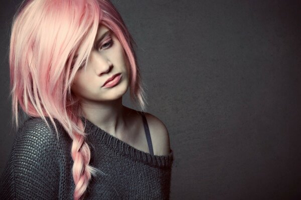 Chica con el pelo rosa sobre un fondo gris