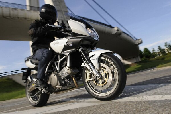 Motociclista con casco negro va a toda velocidad