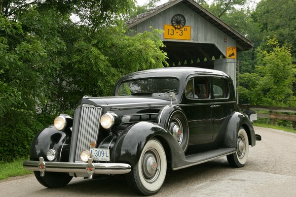 Retro car in black on the background of the bridge