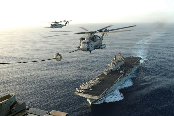 Above is a helicopter, and below is an aircraft carrier