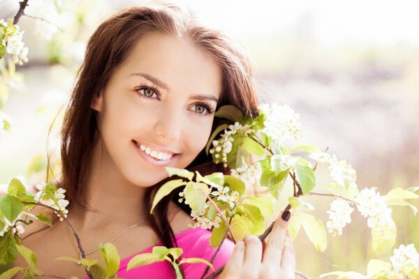 A smiling girl and a blooming tree