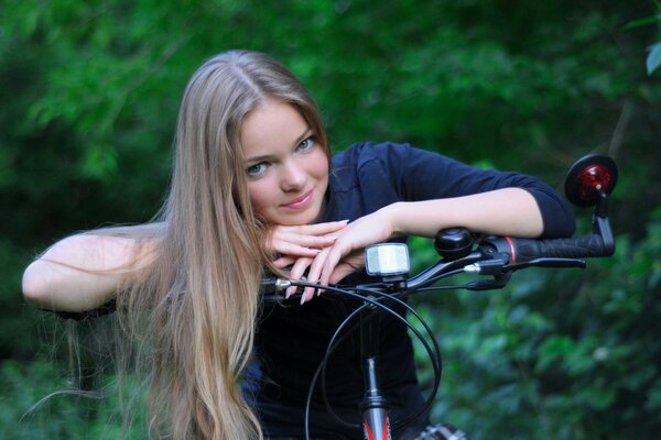 Blonde girl sitting on a bike