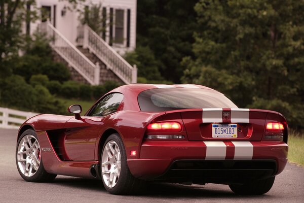 Red Dodge car with headlights on