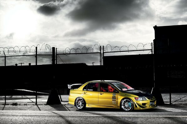 Bright yellow sports car on the background of the gate