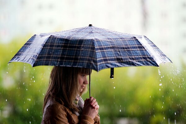 Brünette Mädchen mit Regenschirm im Regen
