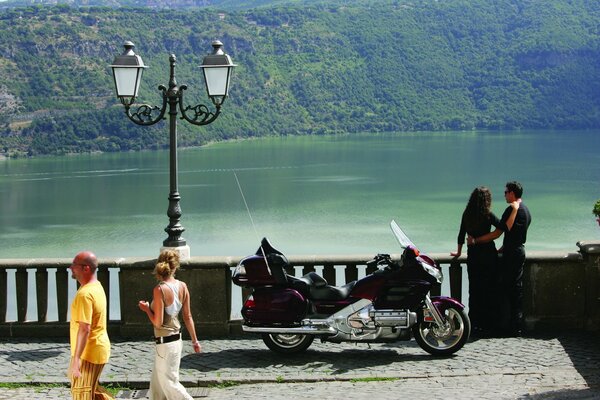 Couple with a motorcycle on the city embankment